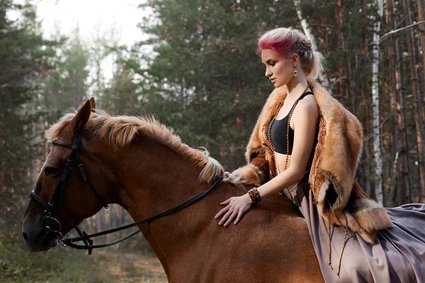 Vrouw op een paard in de herfst. Creatief helder roze make-up op de — Stockfoto