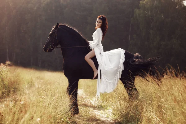 Fille dans une robe longue chevauchant un cheval, une belle femme chevauchant un — Photo