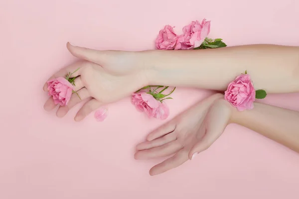 Belleza Mano de una mujer con flores rojas se encuentra en la mesa, pape rosa —  Fotos de Stock