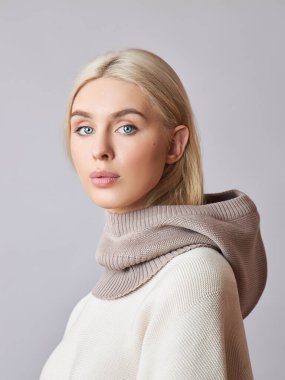 Kafasında başlık olan, sarı saçlı, Avrupalı Müslüman bir kadın. Yumuşak ciltli, doğal kozmetik ürünleri olan güzel bir kız.