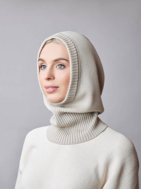 Kafasında başlık olan, sarı saçlı, Avrupalı Müslüman bir kadın. Yumuşak ciltli, doğal kozmetik ürünleri olan güzel bir kız.