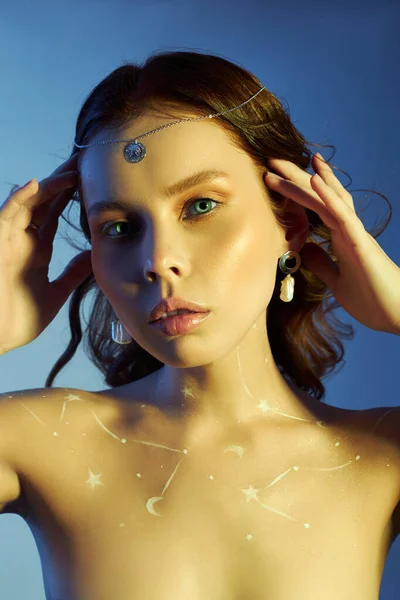 Beauty portrait of a woman with beautiful makeup, earrings and a necklace on the girl. Drawing Cosmos constellation of the zodiac on a woman chest