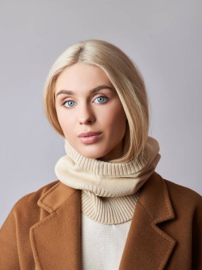 Kafasında başlık olan, sarı saçlı, Avrupalı Müslüman bir kadın. Yumuşak tenli güzel bir kız, doğal kozmetik ürünleri.