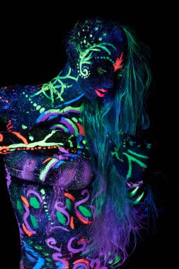 Vücutta ultraviyole ışıkta dans eden sanat kadın vücut sanatı. Kız vücudunun neon rengi üzerinde parlak ve soyut çizimler. Moda ve sanat kadını