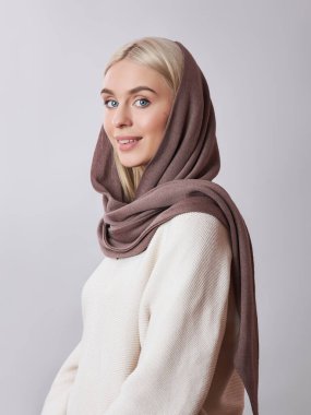 Kafasında başörtüsü olan sarı saçlı Avrupalı Müslüman kadın. Yumuşak ciltli, doğal kozmetik ürünleri olan güzel bir kız.