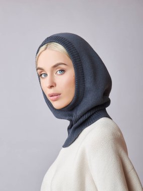 Kafasında başlık olan, sarı saçlı, Avrupalı Müslüman bir kadın. Yumuşak ciltli, doğal kozmetik ürünleri olan güzel bir kız.