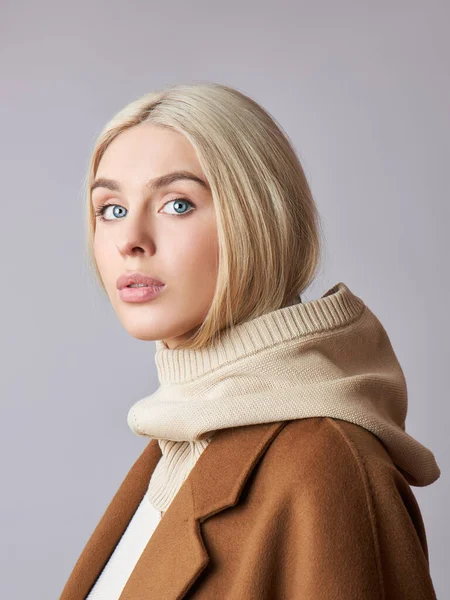 Kafasında başlık olan, sarı saçlı, Avrupalı Müslüman bir kadın. Yumuşak tenli güzel bir kız, doğal kozmetik ürünleri.