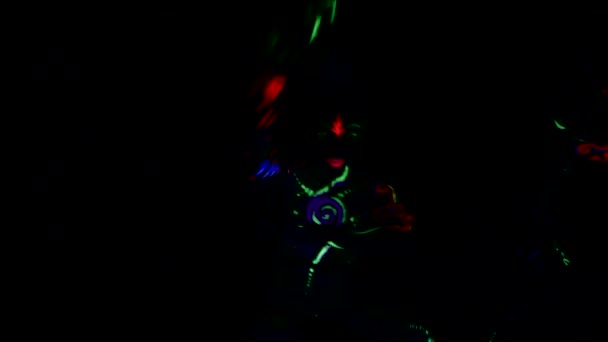 女性は紫外線ネオンライトで踊り 彼女の体は着色された塗料で描かれています — ストック動画