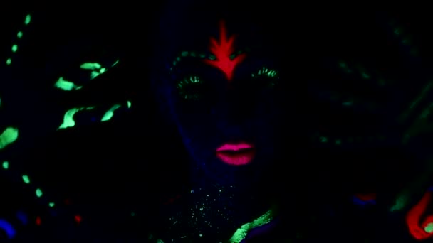 女性は紫外線ネオンライトで踊り 彼女の体は着色された塗料で描かれています — ストック動画