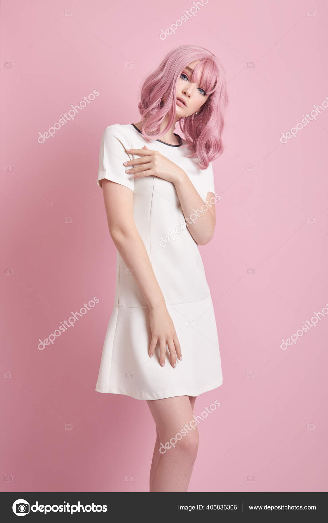 Una niña con un vestido blanco se encuentra sobre un fondo blanco.