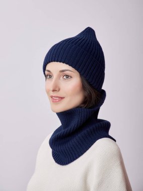 Sonbahar şapkalı güzel bir kadın ve beyaz arka planda Snood atkısı. Sonbahar sıcak giysileri