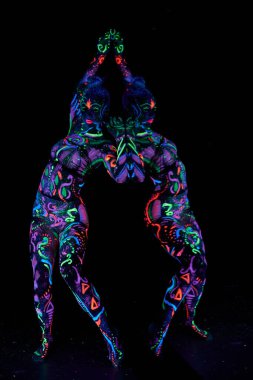 Vücutta ultraviyole ışıkta dans eden sanat kadın vücut sanatı. Kadın vücudunun neon rengi üzerinde parlak ve soyut çizimler. Renkli saç ve yüz.