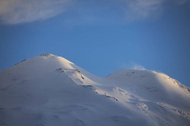 Rusya Kafkasları, Elbrus Dağı muhteşem kuleleri, el değmemiş kar ve buzla süslenmiş. Alp manzarası engebeli tepelerin, dingin vadilerin ve engin mavi gökyüzünün altındaki buzlu buzulların panoramik görüntüleriyle övünür.