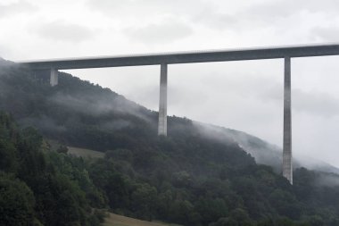 Sis ve bulutlu gökyüzü, Braunsbach yakınındaki ormanlık tepeleri ve Almanya, Kochertalbrucke, en yüksek viyadük, kasvetli yatay delici.