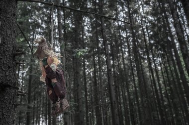 Cadılar Bayramı bağlam eski püskü bir korkuluk ile bir ip--dan karanlık, bir dal ile uzun neredeyse kuru ağaçlar ile uğursuz orman astı.