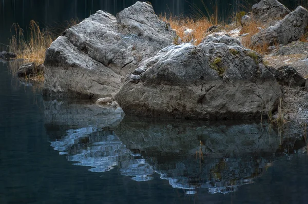 Detail Obrazu Pár Kamenů Pomerančovou Trávou Jejich Odraz Vody Eibsee — Stock fotografie