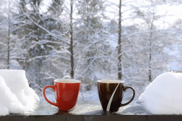 Красные Коричневые Кружки Горячими Напитками Краю Балкона Снегом Бокам Снежной — стоковое фото
