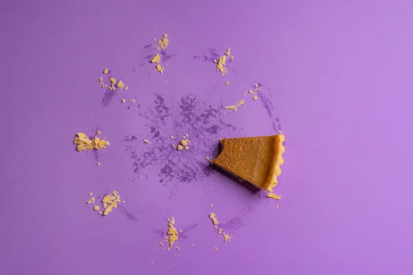 Directly above image of a bitten slice of pumpkin pie and traces of a whole pie. Minimalism. Delicious and irresistible holiday dessert concept.
