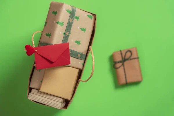 クリスマス プレゼントの紙袋とハンドルと緑の背景に区切られたギフト クリップ赤い封筒 贈与時のコンテキスト — ストック写真