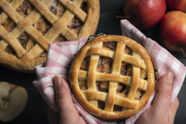 Taze pişmiş bir elmalı turta görünümünü tatlı pasta ve elma meyve içeren bir tablo üzerinde elinde tuttu. Tatil ev yemekleri. Geleneksel tatlı gıda.