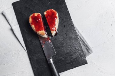 Bir mutfak görünümünü üst, bir kesme tahtası üzerinde çilek soslu iki tablo ile bir ev yapımı frambuazlı pasta dilimlenmiş. Tatlı yemek yemeye hazır.