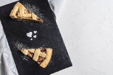 Elmalı turta pudra şekeri kalp şekilleri ile kesme tahtası üzerinde iki dilim masa. Görünümünün üzerinde. Sevgililer günü tatlı. Geleneksel ev yapımı kek.