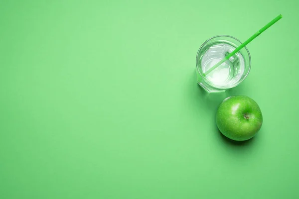 緑の背景にストローで水を一杯近く緑のリンゴのビューよりも上 ミニマリスト デトックス概念 健康的な食事 菜食主義の食事 — ストック写真