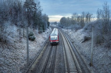 Alman yolcu treni ile karlı doğa ve donmuş ağaçlar, Güneş doğarken seyahat. Kış seyahat bağlam. Modern toplu ulaşım.
