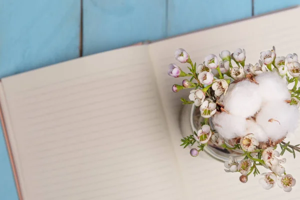 Fehér Virág Elrendezése Egy Üvegben Egy Megnyitott Üres Notebook — Stock Fotó