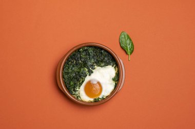 Yumurta ve ıspanak küçük toprak kap içinde desteklenen