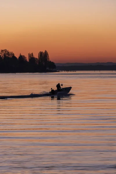 Boat silhouette at sunrise on lake Bodensee, Germany