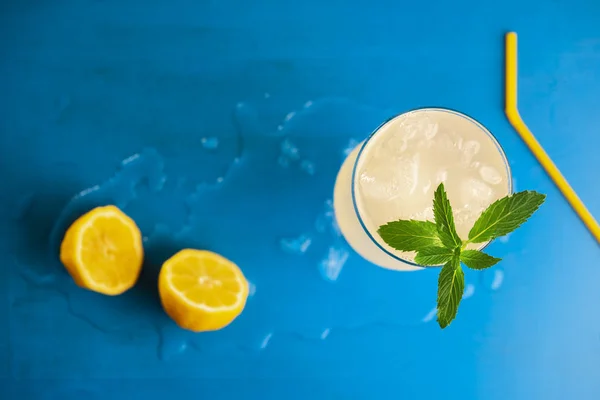 Copo de limonada com gelo e hortelã na mesa azul — Fotografia de Stock