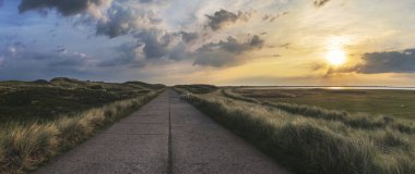 Sylt adasında gün doğumunda ülke yol panoraması