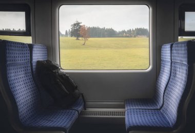 Pencerede sandalye ve sırt çantası ile tren iç