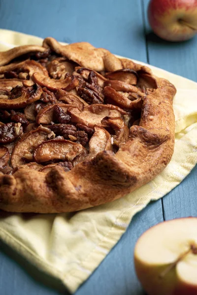 Home-baked apple pie on kitchen towel. Crispy crust and pecan nu