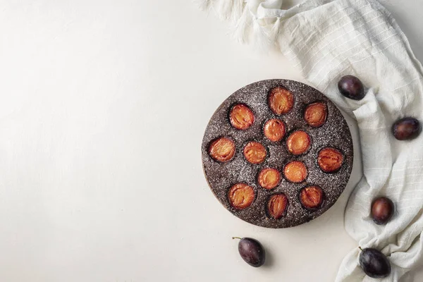 Ciruela y pastel de chocolate en la mesa blanca — Foto de Stock