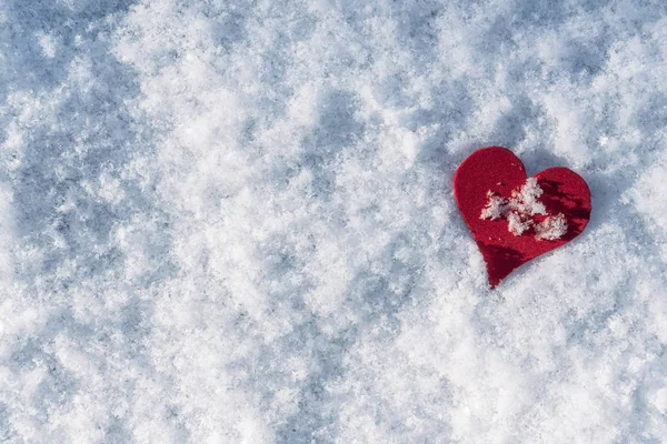 Red heart shape in snow. Snowy winter background — Stock Photo, Image