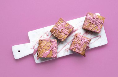 Beyaz kesme tahtası üzerinde pembe çikolatalı kek