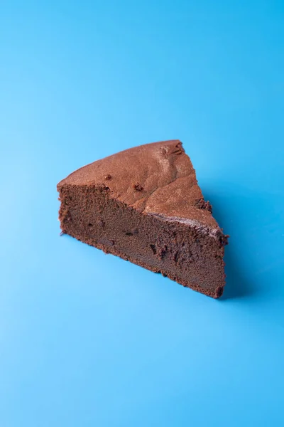 Один кусочек Kladdkaka на синем фоне. Шоколадный пирог — стоковое фото