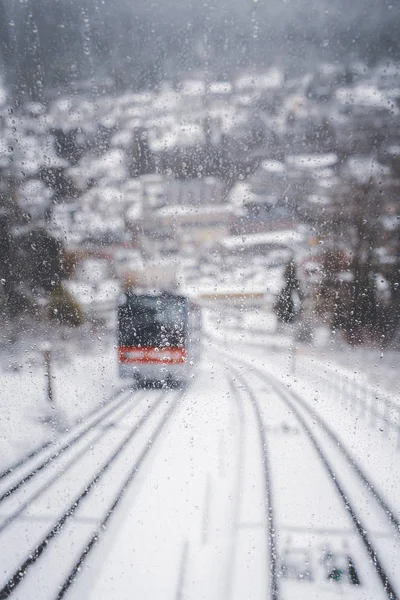 Defokussierte Fensteransicht der Standseilbahn, die durch verschneite Landschaft fährt — Stockfoto