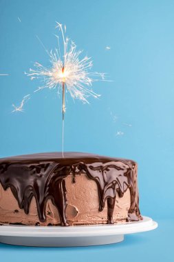 Bir kıvılcım ile çikolata sırlı doğum günü pastası. Yeni yıl pastası
