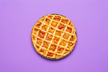 Tepside kafes kabuğu olan kayısı turtası, fırın tazesi, mor arka planda. Lezzetli yaz turtası. Şükran Günü yemeği için kayısılı tart.