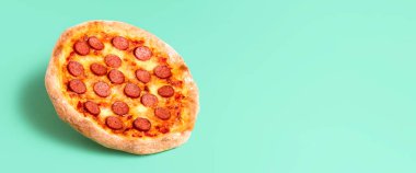 Nane yeşili, pürüzsüz bir arka planda izole edilmiş ev yapımı pizza pepperonisi. Pizza salamı için reklam afişi. İtalyan pizza tarifi. Rahatlatıcı yemek..