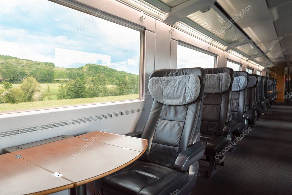 Intercity-Express train interior with empty seats, at business class, in motion. Inside of high-speed German train, at first-class with cozy chairs.