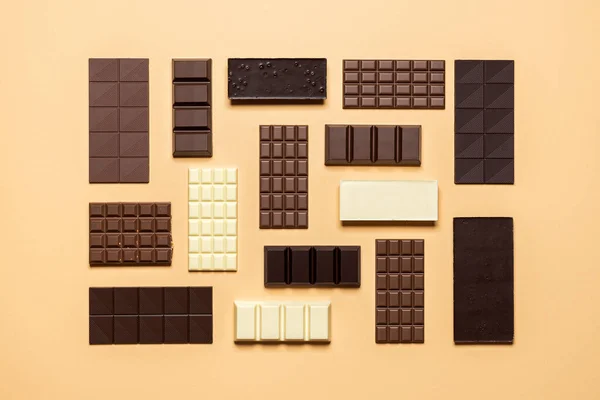 在米色背景下隔离的巧克力条 精美的巧克力收藏 牛奶和白色的顶部视图 分类烘焙巧克力 — 图库照片