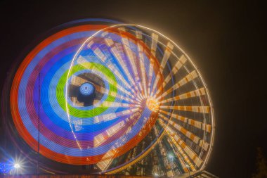 Dönme dolap hareket eğlence parkı, gece aydınlatma. Uzun pozlama.