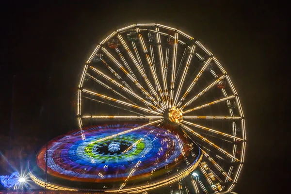 Dönme dolap hareket eğlence parkı, gece aydınlatma. Uzun pozlama.