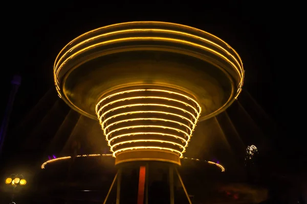 遊園地 夜の照明の動きぼやけのカラフルなチェーン カルーセル ボケと長時間露光の影響 — ストック写真