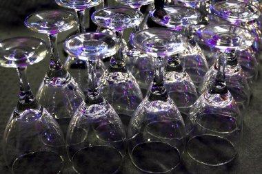 Bulanık fotoğraf kadehlerin veya tablo üzerinde kadehler. Siyah bir zemin üzerine yansıyan mor ve pembe ışık oyunu. Bokeh etkisi.