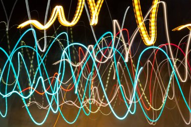 Siyah bir arka plan üzerinde bulanık renkli ışık etkisi Özet. Uzun pozlama fotoğraf hareketli kamera.